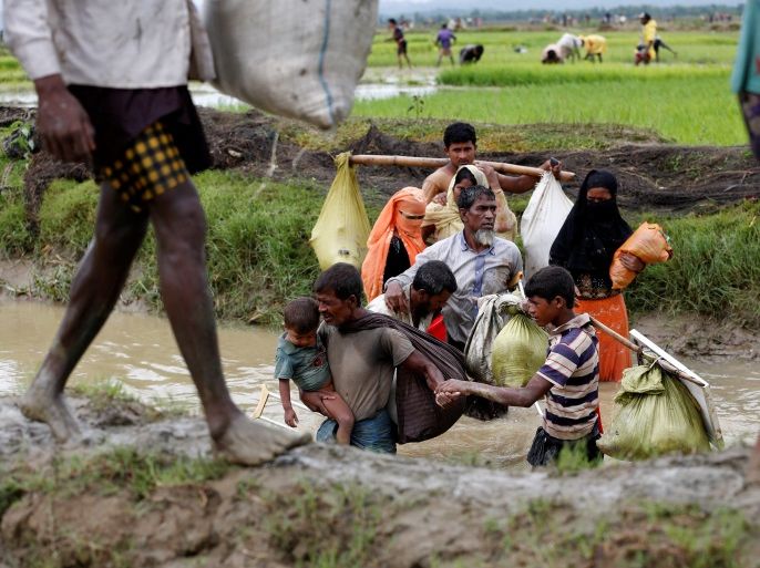 A group of Rohingya refugees cross a canal after travelling over the Bangladesh-Myanmar border in Teknaf, Bangladesh, September 1, 2017. REUTERS/Mohammad Ponir Hossain