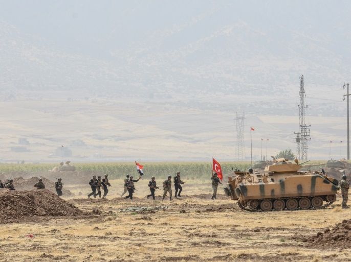 Soldiers holding Turkish and Iraqi flags walk near tanks during a joint military exercise near the Turkish-Iraqi border at Silopi district in Sirnak on September 26, 2017.Turkey launched a military drill with tanks close to the Iraqi border the army said, a week before Iraq's Kurdish region will hold an independence referendum on September 25. / AFP PHOTO / ILYAS AKENGIN (Photo credit should read ILYAS AKENGIN/AFP/Getty Images)