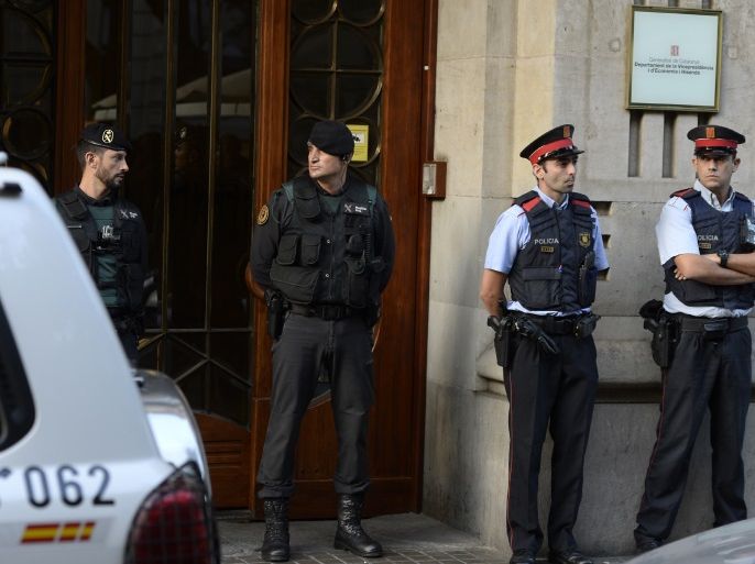 Spanish Civil Guards and Catalan regional police officers 'Mossos D'Esquadra' stand in front of the Economy headquarters of Catalonia's regional government in Barcelona on September 20, 2019, during a search by Spain's Guardia Civil police.The operation comes amid mounting tensions as Catalan leaders press ahead with preparations for an independence referendum on October 1 despite Madrid's ban and a court ruling deeming it illegal. / AFP PHOTO / Josep LAGO
