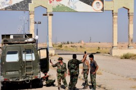 Syrian pro-government stand a on a road on the outskirts of Deir Ezzor on September 10, 2017, as they continue to press forward with Russian air cover in the offensive against Islamic State group jihadists across the province. / AFP PHOTO / George OURFALIAN (Photo credit should read GEORGE OURFALIAN/AFP/Getty Images)