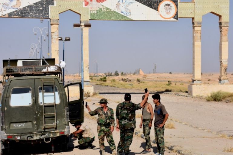 Syrian pro-government stand a on a road on the outskirts of Deir Ezzor on September 10, 2017, as they continue to press forward with Russian air cover in the offensive against Islamic State group jihadists across the province. / AFP PHOTO / George OURFALIAN (Photo credit should read GEORGE OURFALIAN/AFP/Getty Images)