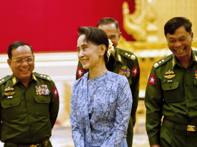 Myanmar's NLD party leader Aung San Suu Kyi smiles with army members during the handover ceremony of outgoing President Thein Sein and new President Htin Kyaw at the presidential palace in Naypyitaw March 30, 2016. REUTERS/Ye Aung Thu/Pool TPX IMAGES OF THE DAY