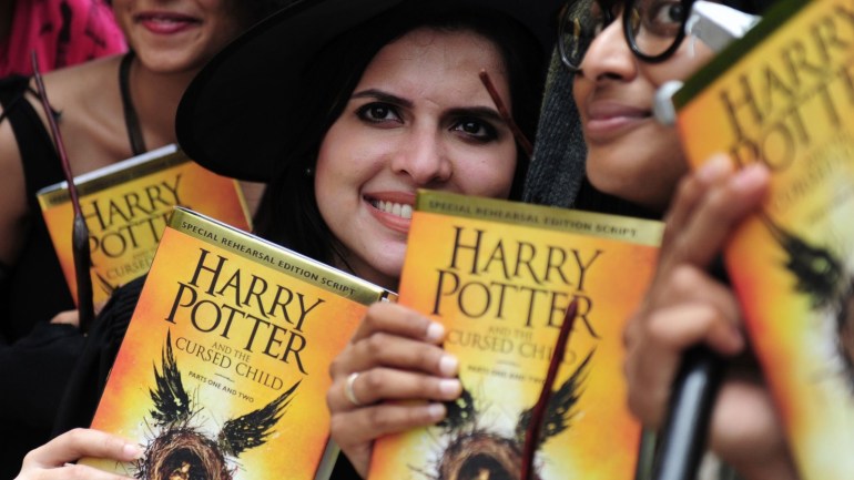 Indian people pose for phootgraphers with copies of J.K. Rowlings new book 'Harry Potter and the Cursed Child' during an event to mark the book launch at a mall in Chennai on July 31, 2016.Harry Potter magic hit Asia, as aspiring witches and wizards crowded into bookstores to get their hands on the first copies of a new play that imagines the hero as an adult. / AFP / ARUN SANKAR (Photo credit should read ARUN SANKAR/AFP/Getty Images)