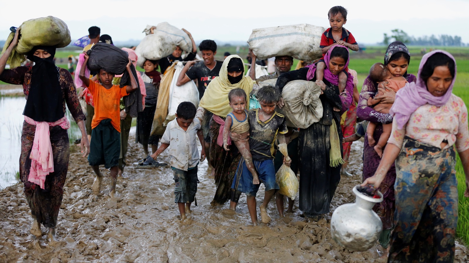 مجموعة من لاجئي الروهينغا يسيرون عبر طريق موحلة داخل الأراضي البنغلاديشية بعد نزوحهم من ميانمار