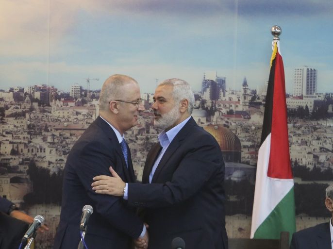 Senior Hamas leader Ismail Haniyeh (R) shakes hands with Palestinian Prime Minister Rami Hamdallah at Haniyeh's house in Gaza City October 9, 2014. Hamdallah arrived in the Hamas-dominated Gaza Strip on Thursday and convened the first meeting of a unity government there since a brief civil war in 2007 between Hamas and forces loyal to the Fatah party. REUTERS/Ibraheem Abu Mustafa (GAZA - Tags: POLITICS CIVIL UNREST)