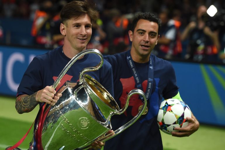 Barcelona's midfielder Xavi Hernandez (R) and Barcelona's Argentinian forward Lionel Messi celebrate with the trophy after the UEFA Champions League Final football match between Juventus and FC Barcelona at the Olympic Stadium in Berlin on June 6, 2015. FC Barcelona won the match 1-3.        AFP PHOTO / PATRIK STOLLARZ        (Photo credit should read PATRIK STOLLARZ/AFP/Getty Images)