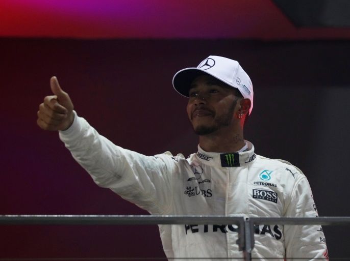 Formula One F1 - Singapore Grand Prix 2017 - Singapore - September 17, 2017 Mercedes' Lewis Hamilton celebrates winning the race on the podium REUTERS/Edgar Su