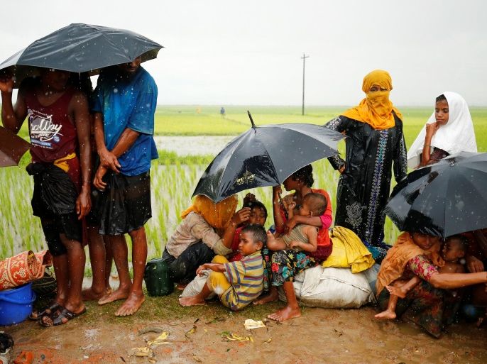Rohingya refugees with children sit in an open place during heavy rain, as they are held by Border Guard Bangladesh (BGB) after illegally crossing the border, in Teknaf, Bangladesh, August 31, 2017. REUTERS/Mohammad Ponir Hossain TEMPLATE OUT