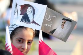 A Qatari girls wears flags bearing the portrait of the Emir of Qatar, Sheikh Tamim bin Hamad bin Khalifa al-Thani as Qataris gather in the streets of Doha to welcome back the Emir upon his returned from his first trip abroad during the ongoing Gulf diplomatic crisis on September 24, 2017. / AFP PHOTO / KARIM JAAFAR (Photo credit should read KARIM JAAFAR/AFP/Getty Images)