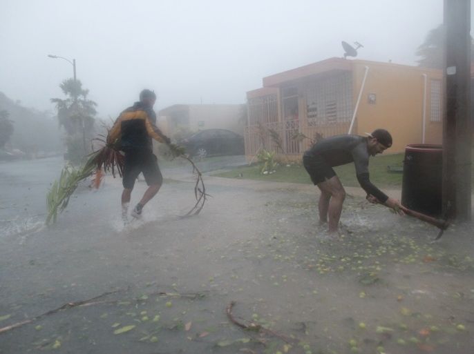 People pick up debris as Hurricane Irma howled past Puerto Rico after thrashing several smaller Caribbean islands, in Fajardo, Puerto Rico September 6, 2017.  REUTERS/Alvin Baez