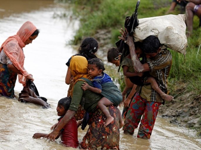 Rohingya refugees wash mud from their clothes while crossing a canal in Teknaf, Bangladesh September 1, 2017. Picture taken September 1, 2017. REUTERS/Mohammad Ponir Hossain