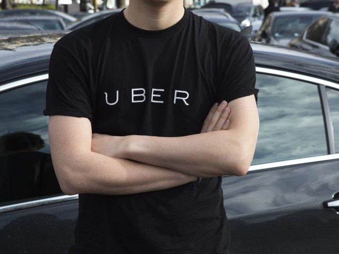 A protester wears a shirt displaying the logo of smartphone ride service Uber during by a protest by non-licensed private hire drivers blocking the Place de la Nation in Paris on February 9, 2016.Members of services known in France as 'voitures de tourisme avec chauffeur' (VTC - Tourism vehicle with driver) have been protesting against assurances the French Prime minister has given to taxis. / AFP / Geoffroy Van der Hasselt (Photo credit should read GEOFFROY VAN DER HASSELT/AFP/Getty Images)