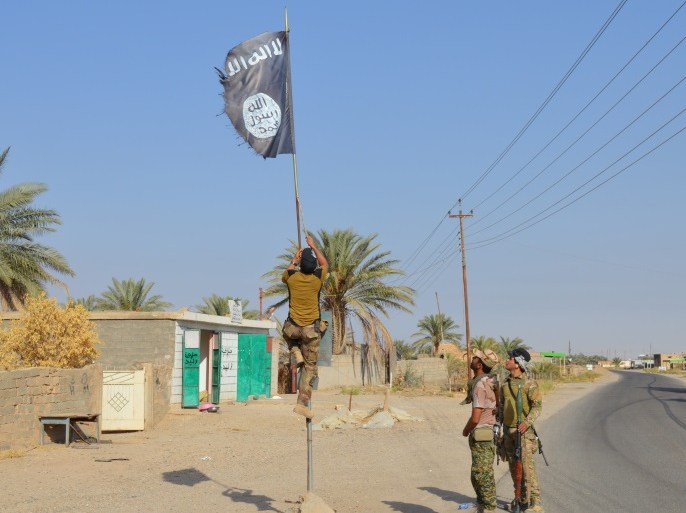 Iraqi army soldiers take down an Islamic State flag in the town of Hit in Anbar province, Iraq October 10, 2016. Picture taken October 10 2016. REUTERS/Stringer