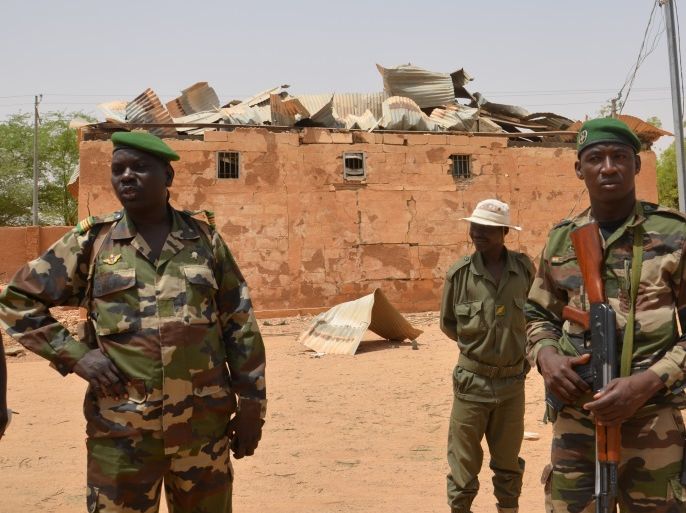 Nigerien soldiers stand near a damaged building in an army base in Agadez, northern Niger on May 26, 2013. Islamist fighters staged twin bombings at the base on May 23. In all, the Agadez attack claimed 24 victims in addition to eight Islamists killed, according to Niger's Defence Minister Mahamadou Karidjo. Islamists groups have claimed responsibility for twin suicide car bombings on an army base and a French-run uranium mine in Niger, in retaliation for the country'