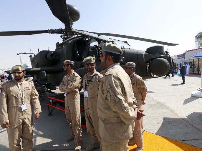 UAE Air Force soldier stand beside an Apache helicopter during Dubai Airshow November 8, 2015. REUTERS/Ahmed Jadallah