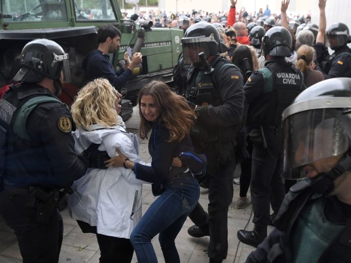 Women clash with Spanish Guardia Civil guards outside a polling station in Sarria de Ter, where Catalan president is supposed to vote, on October 1, 2017, on the day of a referendum on independence for Catalonia banned by Madrid.More than 5.3 million Catalans are called today to vote in a referendum on independence, surrounded by uncertainty over the intention of Spanish institutions to prevent this plebiscite banned by justice. / AFP PHOTO / LLUIS GENE (Photo cr