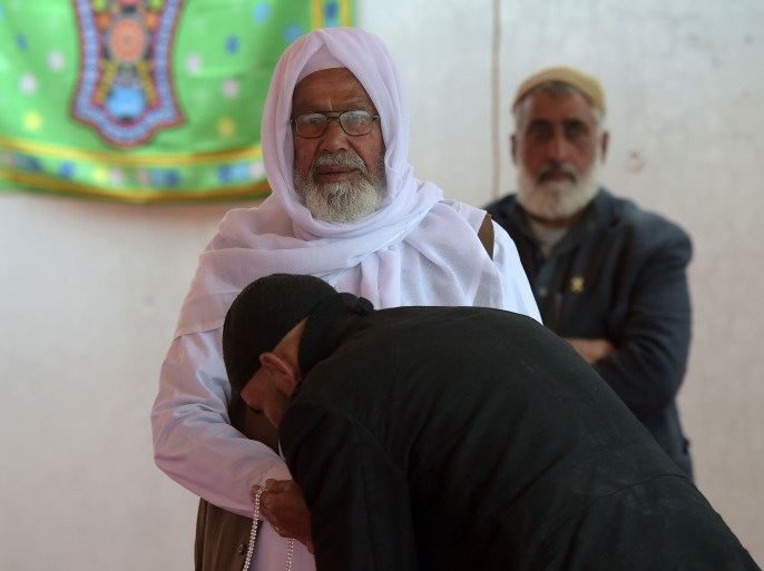 A Pakistani follower kisses the hand of Malik Bashir Awan, the father of Mumtaz Qadri, who was hanged last year for the murder of a governor who criticized Pakistan's blasphemy law and defended a Christian woman, at his tomb in Bara Kahu on the outskirts of Islamabad on February 27, 2017, at the start of a three-day festival marking the anniversary of his hanging on February 29, 2016. Pakistan has renewed its vow to root out extremism after a fresh wave of attacks, but a rose-covered shrine in Islamabad built by radicals to glorify an Islamist murderer sends a different message. Qadri assassinated liberal Punjab governor Salman Taseer in 2011, angered by the politician's reformist stance on Pakistan's controversial blasphemy laws. The state's decision to execute him provoked uproar among Islamists. / AFP / AAMIR QURESHI (Photo credit should read AAMIR QURESHI/AFP/Getty Images)