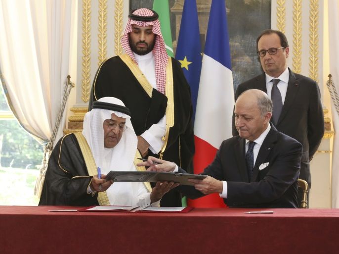 French Foreign Minister Laurent Fabius (R), exchanges documents with Dr. Hashim Yamani, the President of King Abdullah City for Atomic and Renewable Energy (KACARE), after signing an agreement between France and Saudi Arabia, in front of French President Francois Hollande (Top R), and Saudi Arabia's Deputy Crown Prince Mohammed bin Salman, at the Elysee Palace in Paris, France, June 24, 2015. A French government statement says the two countries are finalizing contracts