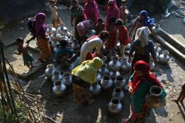 Rohingya refugees fill pots for drinking water from a hand pump at Nayapara refugee campin Teknaf on October 27, 2017. / AFP PHOTO / Tauseef MUSTAFA (Photo credit should read TAUSEEF MUSTAFA/AFP/Getty Images)
