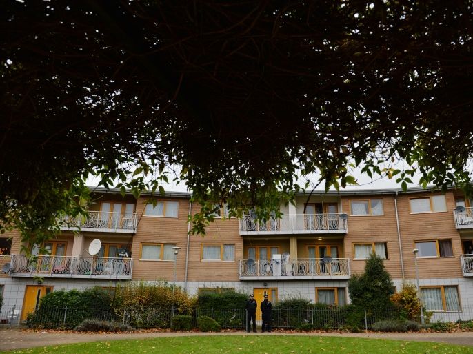 Police stand guard outside a block of residential flats in south London on November 24, 2013 where investigations have centred following the arrest of a man and a woman suspected of holding three women captive in a London house for 30 years. The suspects are of Indian and Tanzanian origin and two of the victims were part of a political 'collective', police said. Police carried out house-to-house enquiries on November 23, speaking to residents living near the south London address where the suspects were arrested. The exact location has not been officially revealed but the police operation centred on a modern, low-rise block of flats in Brixton. AFP PHOTO / BEN STANSALL (Photo credit should read BEN STANSALL/AFP/Getty Images)