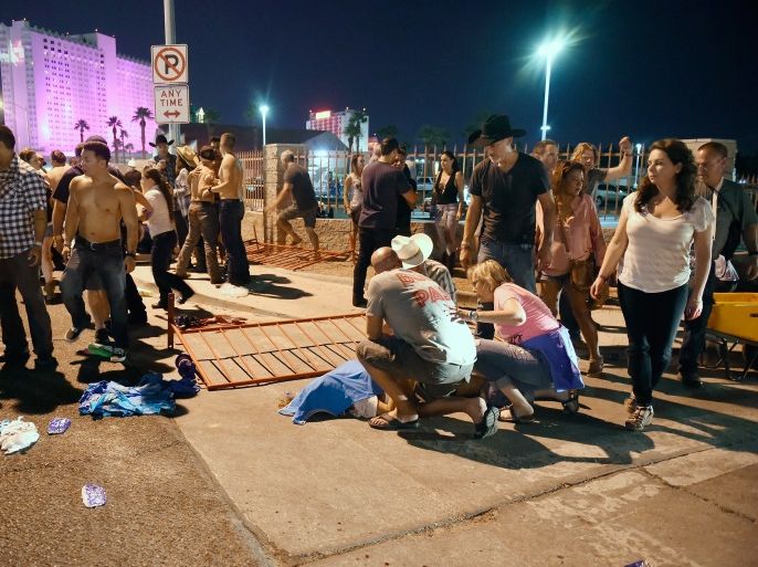 LAS VEGAS, NV - OCTOBER 01: People tend to the wounded outside the Route 91 Harvest Country music festival grounds after an apparent shooting on October 1, 2017 in Las Vegas, Nevada. There are reports of an active shooter around the Mandalay Bay Resort and Casino. (Photo by David Becker/Getty Images)