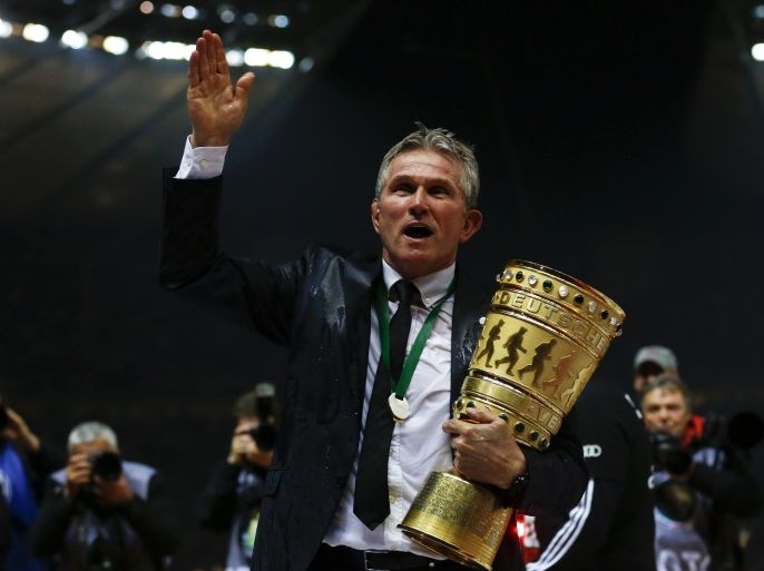 Bayern Munich's coach Jupp Heynckes holds the trophy after he was showered with beer as his team celebrates victory over VfB Stuttgart in their German soccer cup (DFB Pokal) final match at the Olympic Stadium in Berlin June 1, 2013. REUTERS/Thomas Peter (GERMANY - Tags: SPORT SOCCER) DFB RULES PROHIBIT USE IN MMS SERVICES VIA HANDHELD DEVICES UNTIL TWO HOURS AFTER A MATCH AND ANY USAGE ON INTERNET OR ONLINE MEDIA SIMULATING VIDEO FOOTAGE DURING THE MATCH.