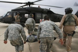 U.S. soldiers rush an injured comrade towards a Medivac Blackhawk helicopter of the Charlie Company 2-227, Aviation Battalion called