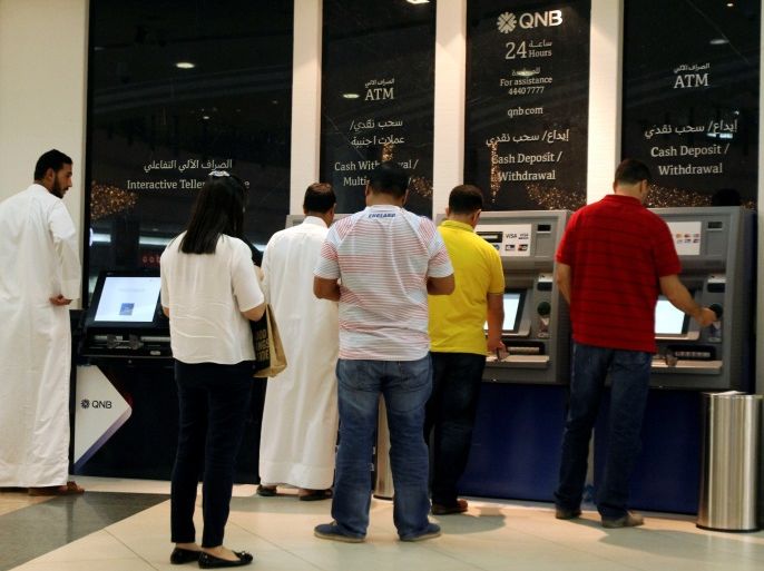 People use ATM machines at Qatar National Bank in Doha, Qatar, June 13, 2017. REUTERS/Naseem Zeitoon