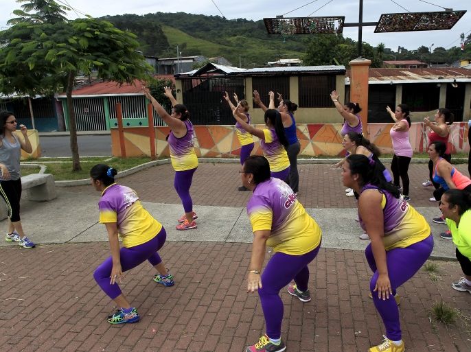 Andrea Abarca, (L) leads an aerobics class in Los Guidos de Desamparados July 23, 2015. More than 300 women participated in a physical health program organized by Abarca, which aims to combat obesity and sedentary behavior in poor women living in a slum. The National Nutrition Survey shows that the Costa Rican population has 62.4 percent of adult men who are obese , while among women the percentage was 77.3, according to local media. REUTERS/Juan Carlos Ulate