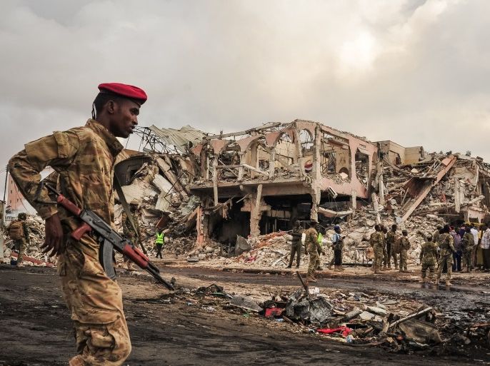 TOPSHOT - EDITORS NOTE: Graphic content / Somali soldiers patrol on the scene of the explosion of a truck bomb in the centre of Mogadishu, on October 15, 2017.A truck bomb exploded outside a hotel at a busy junction in Somalia's capital Mogadishu on October 14, 2017 causing widespread devastation that left at least 20 dead, with the toll likely to rise. / AFP PHOTO / Mohamed ABDIWAHAB (Photo credit should read MOHAMED ABDIWAHAB/AFP/Getty Images)