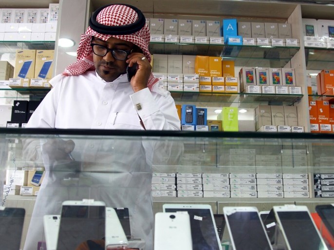 A Saudi vendor speaks on his phone as he waits for customers at a mobile shop in Riyadh, Saudi Arabia March 21, 2016. In early March, the Ministry of Labour announced that within six months foreigners would be banned from selling and maintaining mobile phones and accessories for them, in an effort to keep open more jobs for Saudi citizens. Picture taken March 21, 2016. REUTERS/Faisal Al Nasser