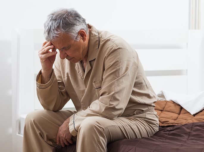 القلق - الصداع - Senior man can not sleep. He is sitting on his bed with headache.