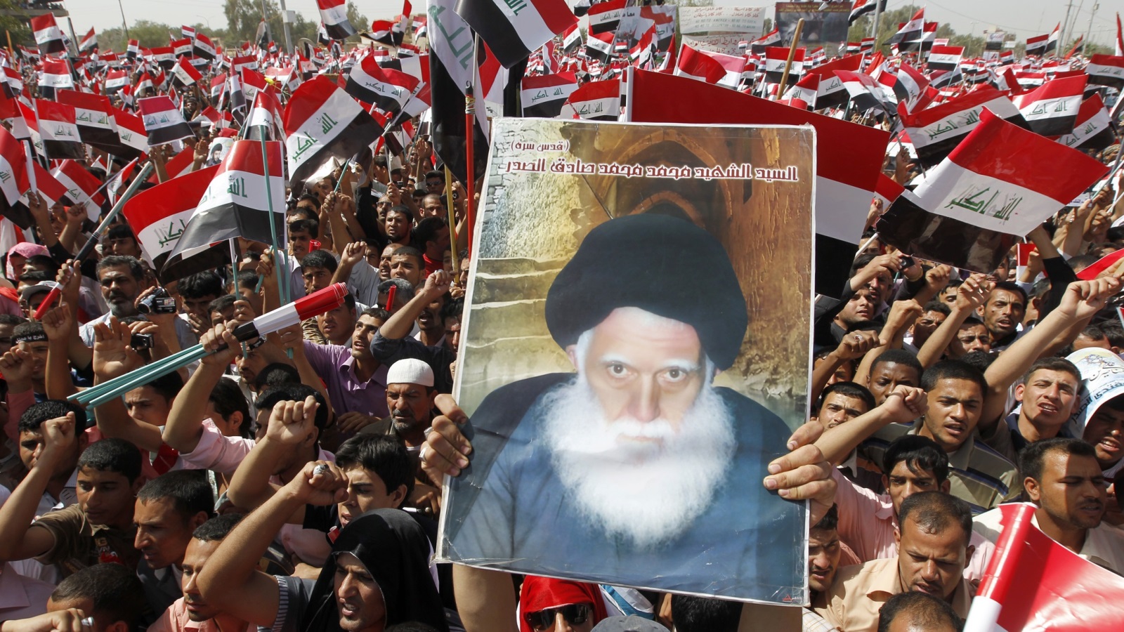 عراقيون شيعة يرفعون صورة صادق الصدر (رويترز)