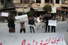 Syrians hold banners in Kafr Batna, in the besieged rebel-held Eastern Ghouta region on the outskirts of the capital Damascus, calling for the end of the seige as a convoy carrying aid for some 40,000 people entered the area on October 30, 2017.The delivery comes a week after residents and aid groups warned of a mounting hunger crisis in the region. / AFP PHOTO / ABDULMONAM EASSA (Photo credit should read ABDULMONAM EASSA/AFP/Getty Images)