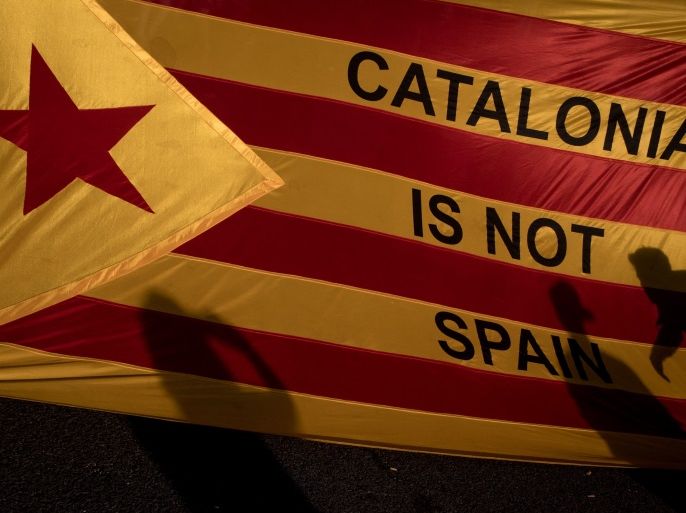 BARCELONA, SPAIN - OCTOBER 03: Protesters shadows are seen on a Catalan flag as thousands of citizens gather in Plaza Universitat during a regional general strike to protest against the violence that marred Sunday's referendum vote on October 3, 2017 in Barcelona, Spain. According to the Catalonia's government more than two million people voted on Sunday in the referendum of Catalonia, which the Government in Madrid had declared illegal and undemocratic. Officials said that 90% of votes cast were for independence. The Catalan goverment's spokesman said that an estimated of 770,000 votes were lost as a result of 400 polling stations being raided by Spanish police. Hundreds of citizens were injured during the police crackdown. (Photo by Chris McGrath/Getty Images)