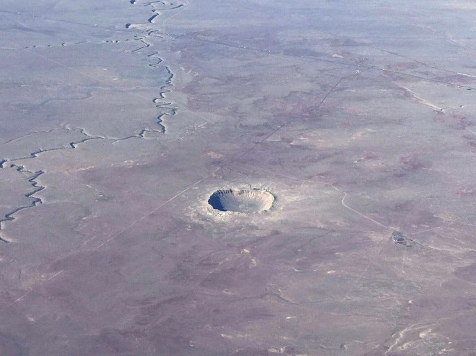The Meteor Crater near Winslow, Arizona, is seen from a plane Januray 30, 2017.The Meteor Crater, sometimes known as the Barringer Crater and formerly as the Canyon Diablo crater, is a famous impact crater. It is the breath-taking result of a collision between an asteroid traveling 26,000 miles per hour and planet Earth approximately 50,000 years ago. Meteor Crater is nearly one mile across, 2.4 miles in circumference and more than 550 feet deep. / AFP / Daniel SLIM