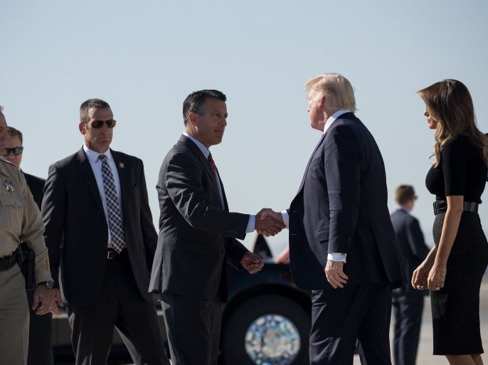 LAS VEGAS, NV - OCTOBER 4: Clark County Sheriff Joe Lombardo (L) and first lady Melania Trump look on as Nevada Governor Brian Sandoval shakes hands with President Donald Trump upon arrival at McCarran International Airport, October 4, 2017 in Las Vegas, Nevada. Trump is scheduled to visit with victims and first responders from Sunday night's mass shooting during his trip to Las Vegas. (Photo by Drew Angerer/Getty Images)