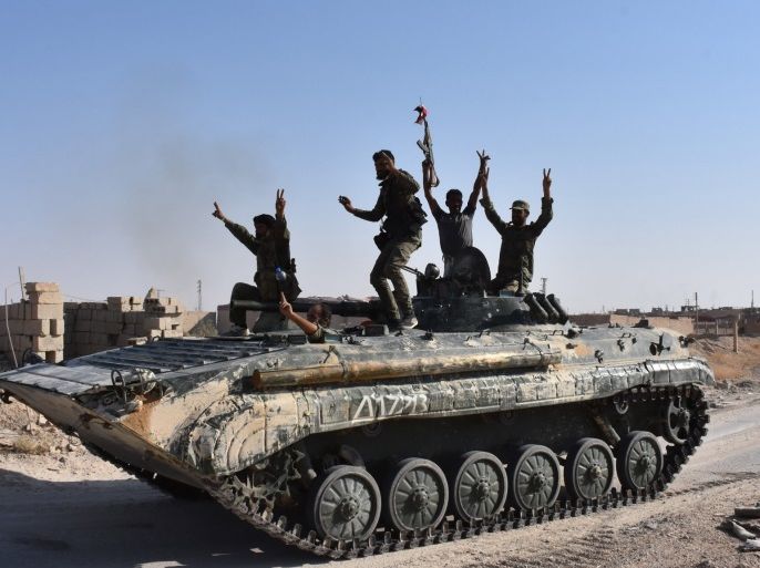 Syrian government forces celebrate in the eastern Syrian city of Deir Ezzor on September 11, 2017 as they continue to press forward with Russian air cover in the offensive against Islamic State group jihadists across the province.Syrian army reinforcements arrived in Deir Ezzor for a new push against the Islamic State group, as a second day of suspected Russian strikes killed 19 civilians in the area. / AFP PHOTO / George OURFALIAN (Photo credit should read GEORG