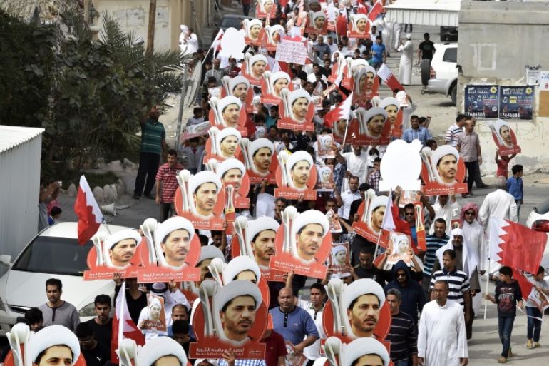 epa04617811 Protesters carrying pictures of jailed opposition leader Sheikh Ali Salman