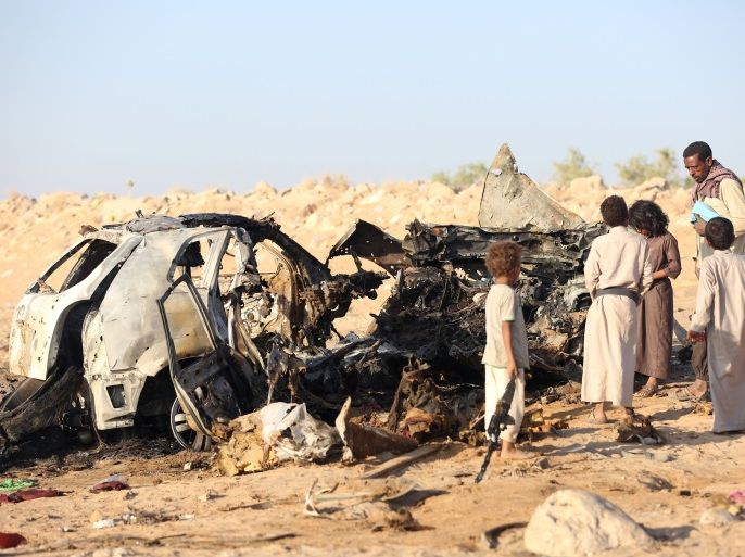 People inspect the wreckage of a car hit by a drone air strike near the northern city of Marib, Yemen November 3, 2017. REUTERS/Ali Owidha