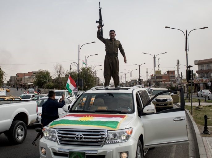 KIRKUK, IRAQ - SEPTEMBER 25: Peshmerga soldiers fire their guns in the air to celebrate the referendum on the road outside a voting station on September 25, 2017 in Kirkuk, Iraq. Despite strong objection from neighboring countries and the Iraqi government. Some five million Kurds took to the polls today across three provinces in the historic independence referendum. (Photo by Chris McGrath/Getty Images)