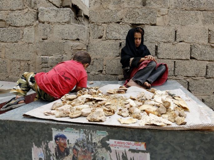 epa06170792 Yemeni children sit near remains of dry bread at a slum in Sana'a