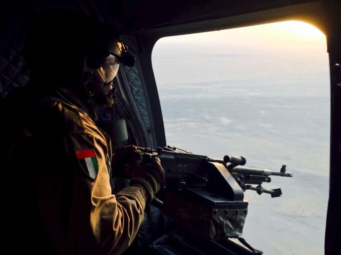 A soldier from the United Arab Emirates armed with a machine gun watches over Yemeni territory while riding a Chinook helicopter en route to a Saudi-led coalition air base in the kingdom September 17, 2015. Armed with high-tech Western weaponry, Gulf Arab soldiers are fighting with newfound determination against what they see as the expanding influence of Iran, their non-Arab and Shi'ite Muslim arch-foe, in a war that has ravaged Yemen for six months. The oil-producing province of Marib has become a key battlefield between Iranian-allied Houthi militia and a coalition of Yemenis and Emirati, Saudi and Bahraini troops. Marib forms a gateway to the Yemeni capital Sanaa 120 km (75 miles) to the west, which the Houthis seized last year. REUTERS/Abdelhadi al-Ramahi