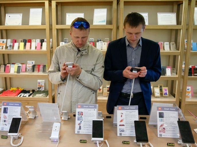 Men try out Xiaomi smartphones at the company's store in central Kiev, Ukraine May 17, 2017. REUTERS/Valentyn Ogirenko