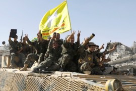 Syrian Democratic Forces (SDF) fighters ride atop of military vehicle as they celebrate victory in Raqqa, Syria, October 17, 2017. REUTERS/Erik De Castro
