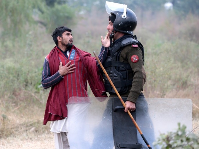A demonstrator detained by a policeman gestures near the Faizabad junction in Islamabad, Pakistan November 25, 2017. REUTERS/Caren Firouz