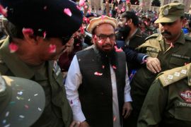 Hafiz Saeed is showered with flower petals as he walks to court before a Pakistani court ordered his release from house arrest in Lahore, Pakistan November 22, 2017. REUTERS/Mohsin Raza