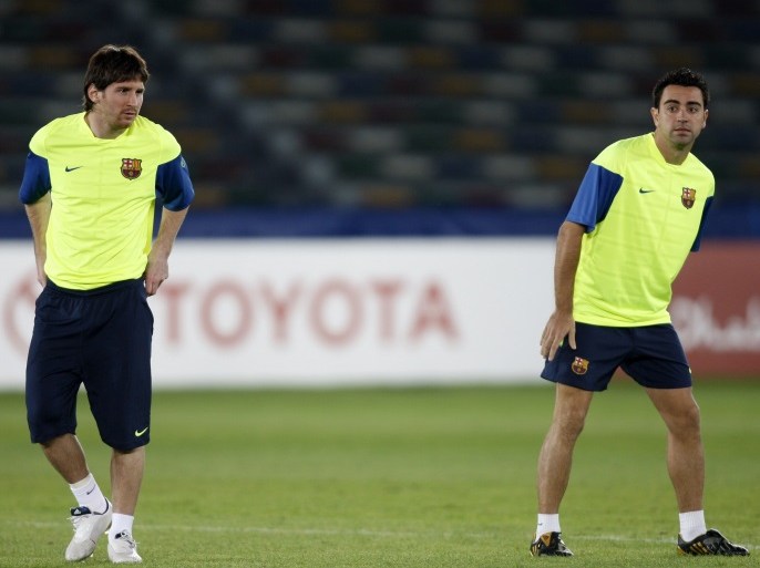 Barcelona's Xavi and Lionel Messi (L) attend a training session at Zayed Sports City stadium in Abu Dhabi December 15, 2009. Barcelona play CONCACAF champion Atlante on Wednesday in a FIFA Club World Cup semi-final match. REUTERS/Fadi Al-Assaad (UNITED ARAB EMIRATES - Tags: SPORT SOCCER)