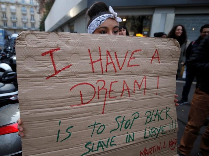 A woman holds a placard with the message