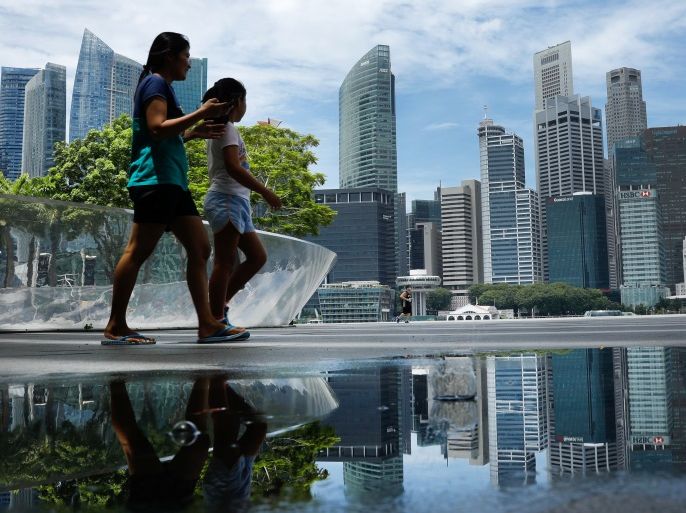 People pass the skyline of Singapore October 11, 2017. REUTERS/Edgar Su